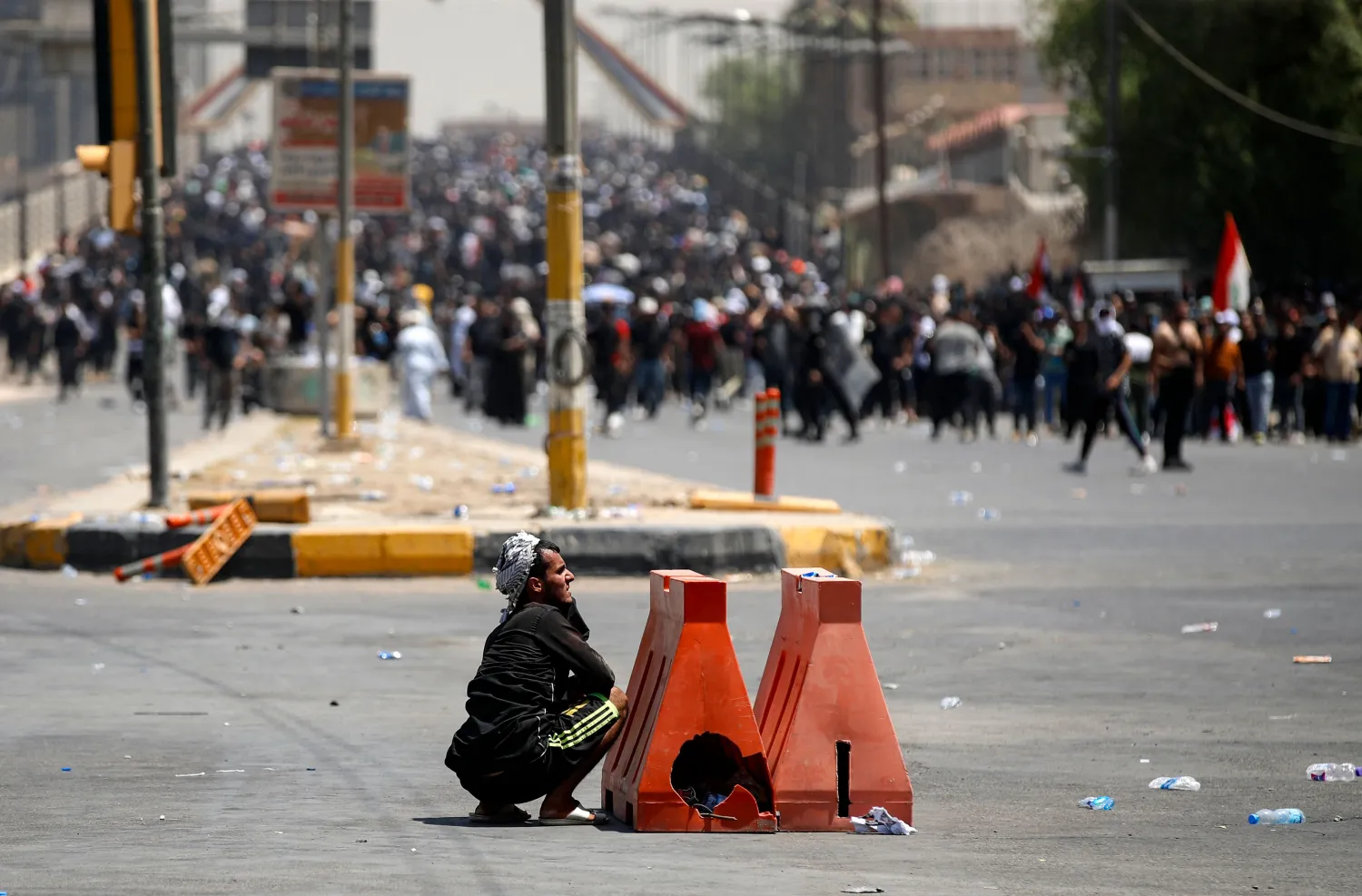 عراقي يختبئ بعد وقوع اشباكات مع القوى الامنية خلال تظاهرة وسط بغداد (أ.ف.ب)