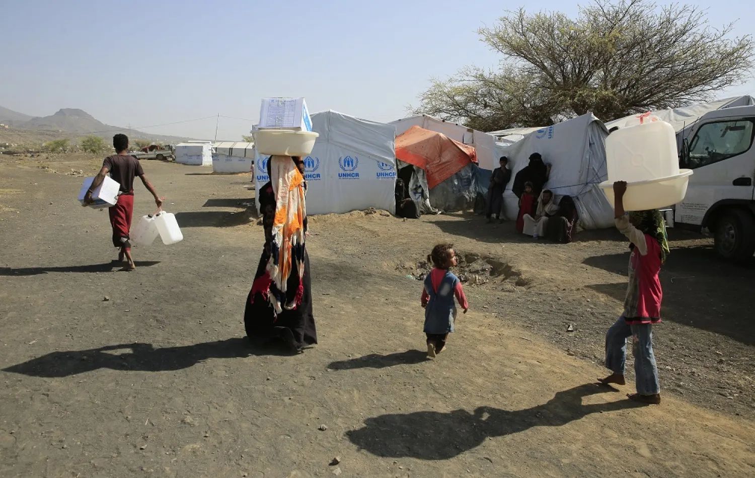 Displaced Yemenis walk through a camp for Internally Displaced Persons (IDPs) amid a UN-brokered nationwide truce, on the outskirts of Sanaa, Yemen, 30 July 2022 (issued 31 July 2022). (EPA)