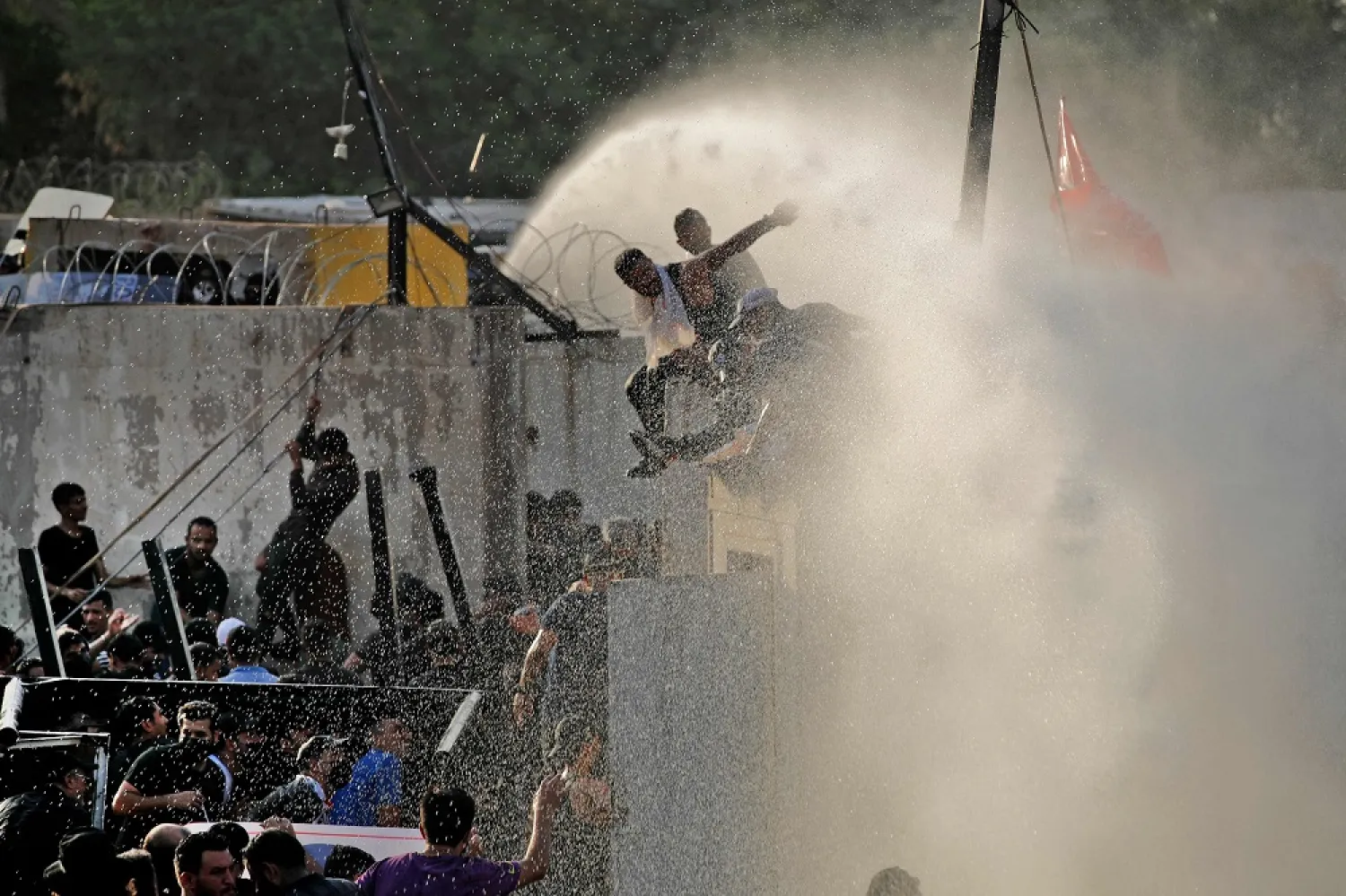 Security forces use a water cannon to prevent supporters of the Coordination Framework from entering the capital Baghdad's high-security Green Zone on August 1, 2022, during a counter-protest against Sadr's loyalists who have been occupying parliament. (AFP)