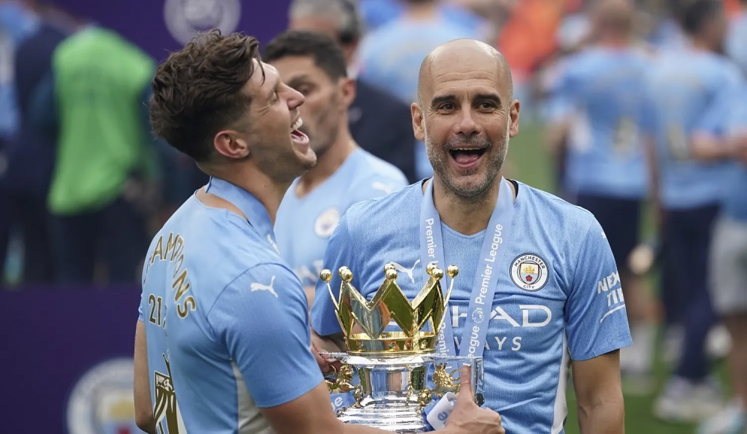 Manchester City's head coach Pep Guardiola, right, smiles with trophy after winning the 2022 English Premier League title at the Etihad Stadium in Manchester, England, on May 22, 2022. (AP)