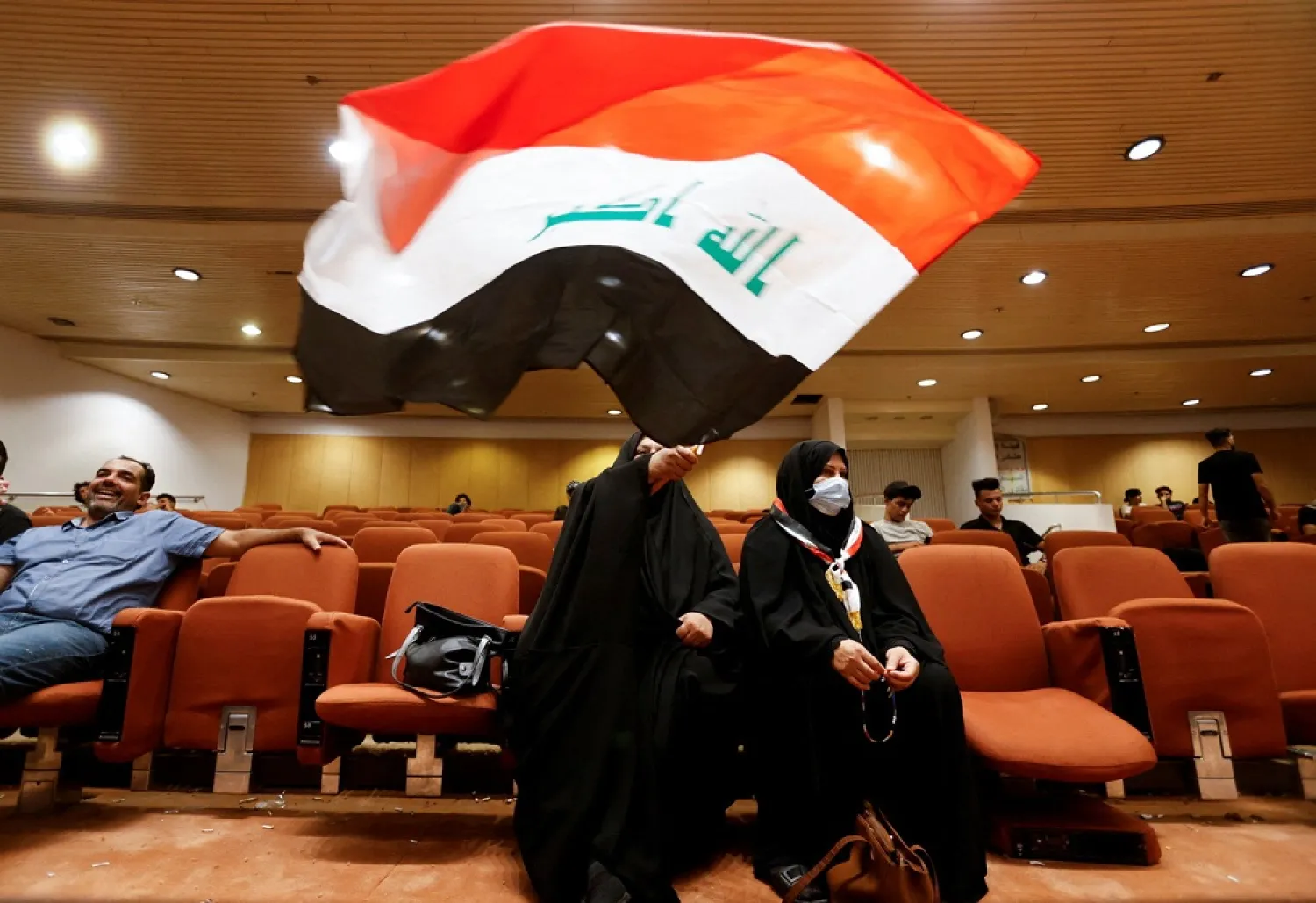 A woman holds an Iraqi flag as supporters of Iraqi populist leader Moqtada al-Sadr gather during a sit-in at the parliament building, amid political crisis in Baghdad, Iraq August 3, 2022. (Reuters)