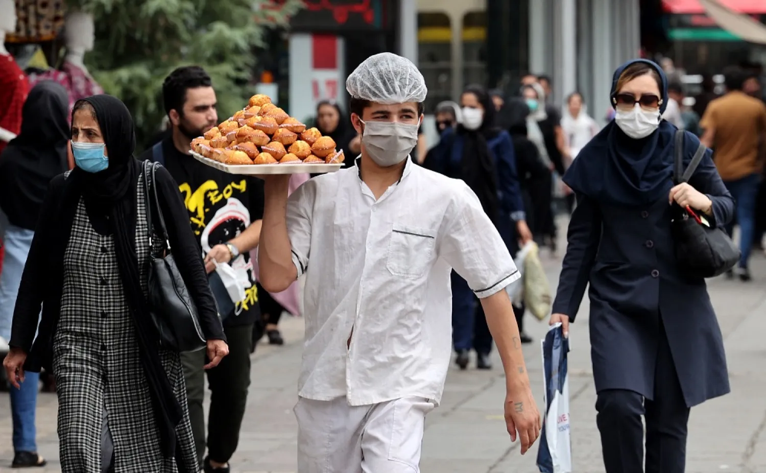 Iranians walk at Valiasr square in the capital Tehran, on July 31 2022. (AFP)