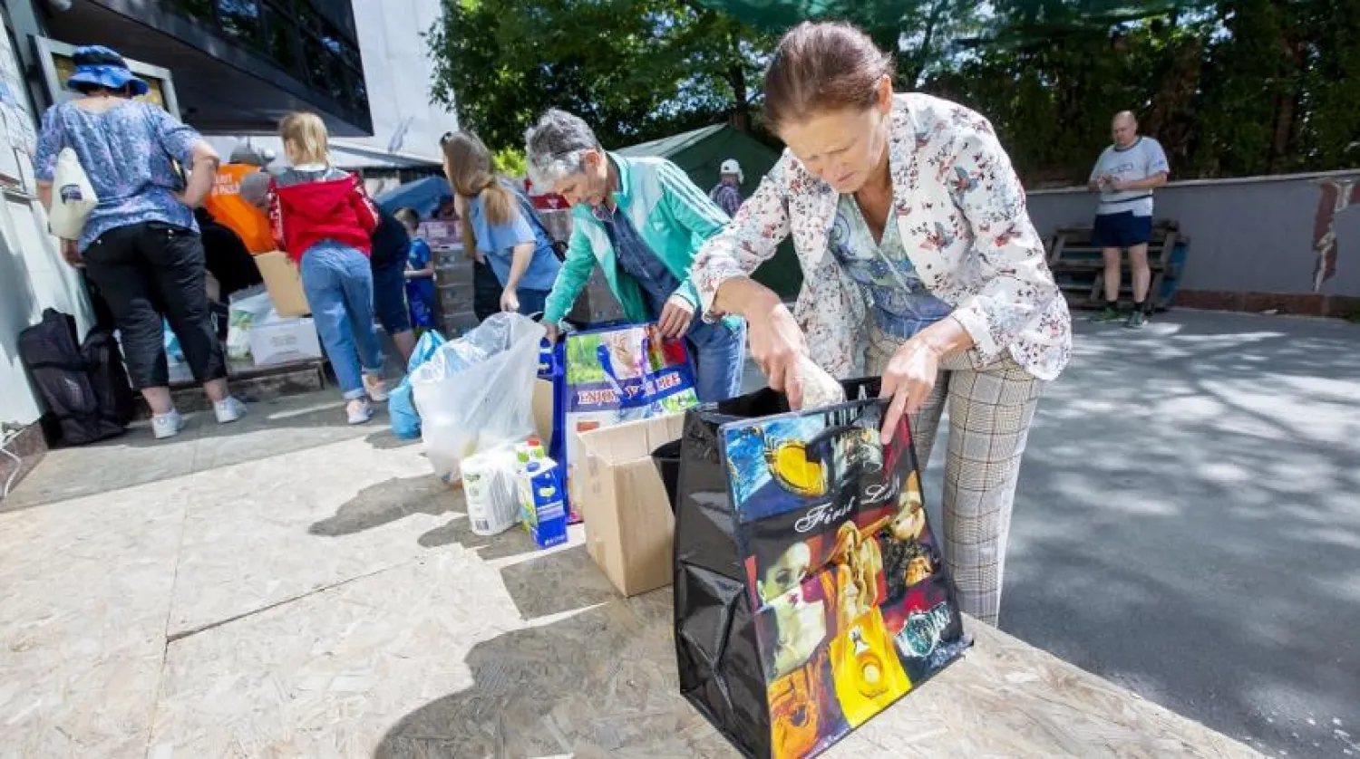 Ukrainian people receive humanitarian aid at a refugee camp set up at the Patria-Lukoil center in Chisinau, Moldova, 12 July 2022. (EPA)
