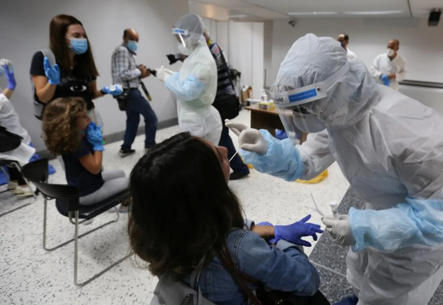 FILE PHOTO: Health workers take swab samples from passengers who arrived at Beirut international airport on its re-opening day following the coronavirus disease (COVID-19) outbreak, in Beirut, Lebanon July 1, 2020. REUTERS/Aziz Taher