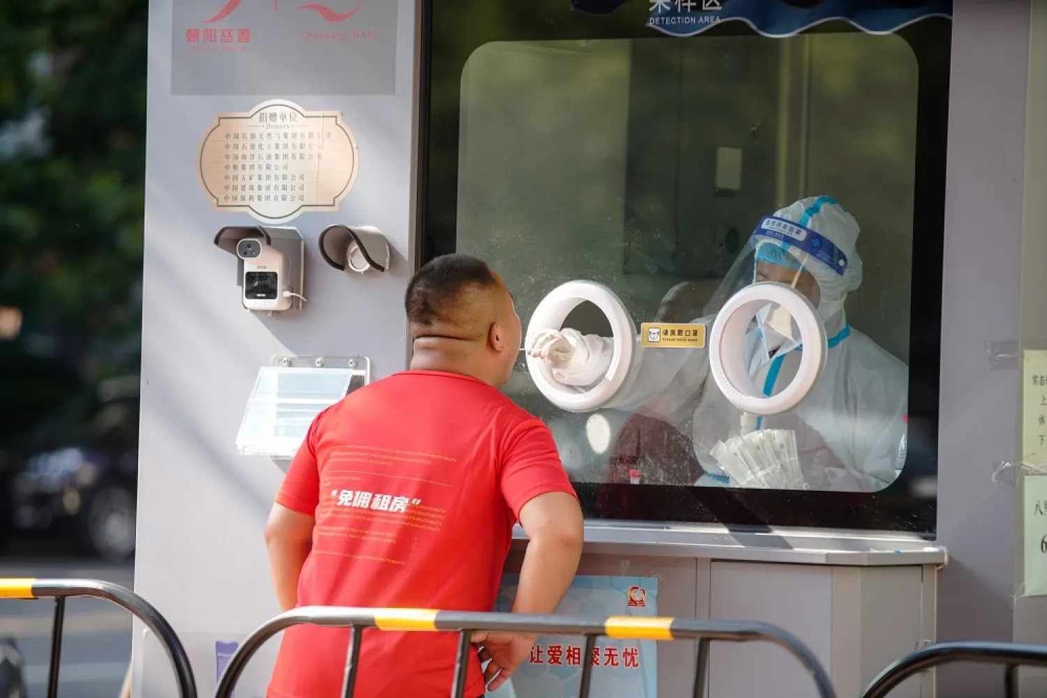 A medical worker takes a swab sample from a man to be tested for COVID-19 at a swab collection site in Beijing, China, 05 August 2022. (EPA)
