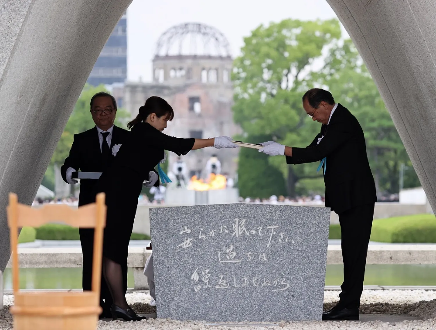 The list of atomic bombing victims is given to the mayor of Hiroshima Kazumi Matsui (R) by a representative of the victims during a ceremony at Peace Memorial Park in Hiroshima, western Japan, 06 August 2022. (EPA)