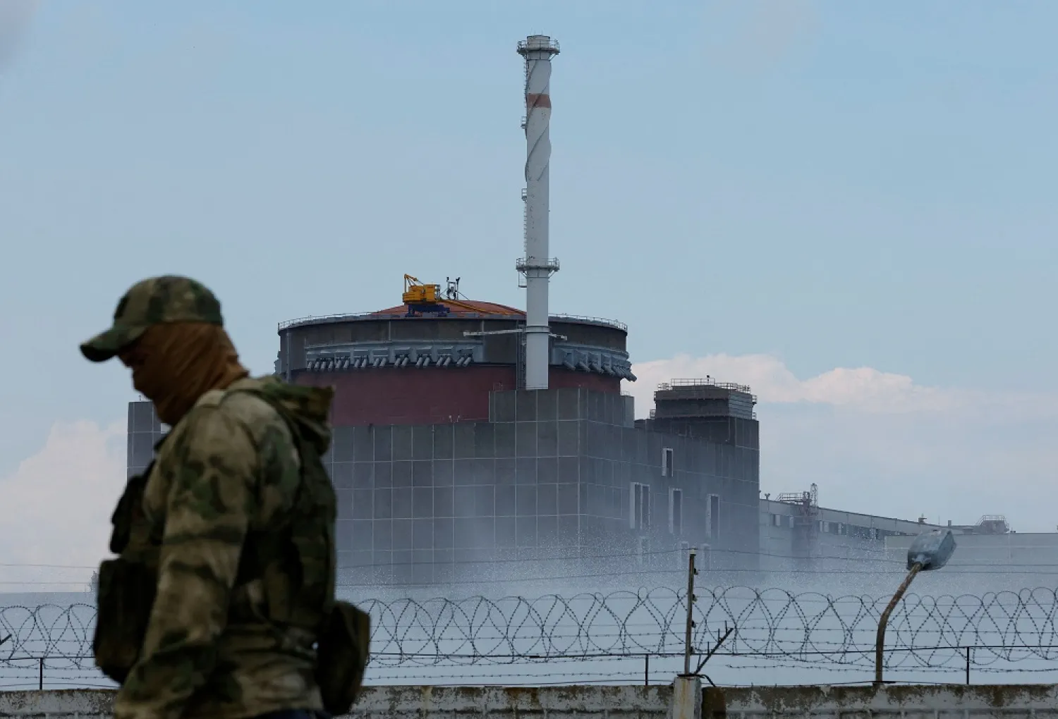 A serviceman with a Russian flag on his uniform stands guard near the Zaporizhzhia Nuclear Power Plant in the course of Ukraine-Russia conflict outside the Russian-controlled city of Enerhodar in the Zaporizhzhia region, Ukraine August 4, 2022. (Reuters)