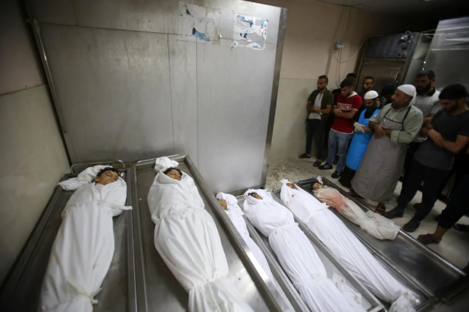 فلسطينيون يؤدون صلاة الجنازة على أسرة قضت في مخيم جباليا بغزة (د.ب.أ)