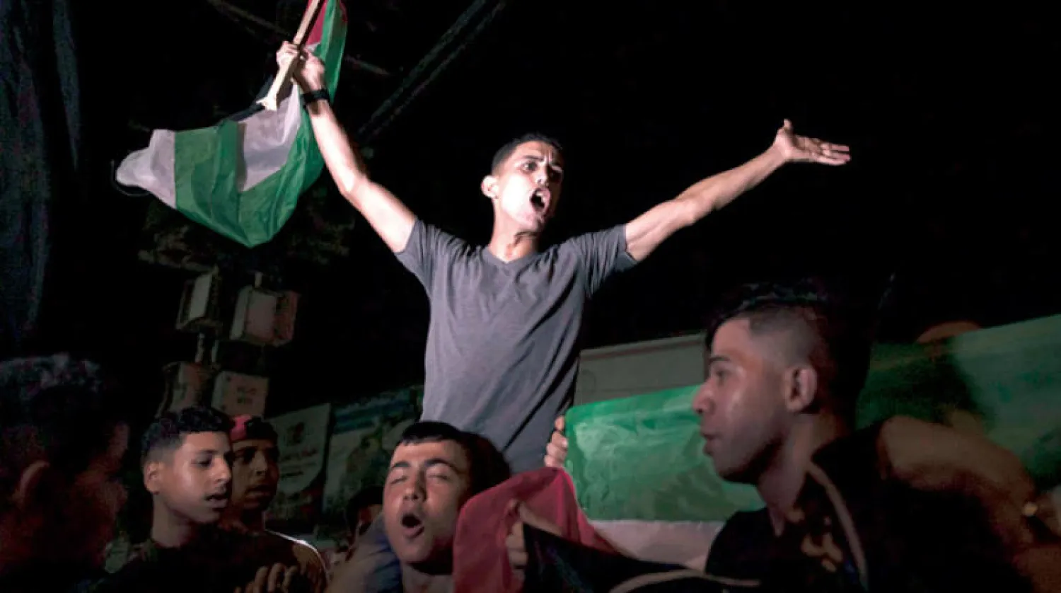 فلسطينيون يحتفلون باتفاق وقف إطلاق النار في مدينة غزة فجر الاثنين (أ.ف.ب)