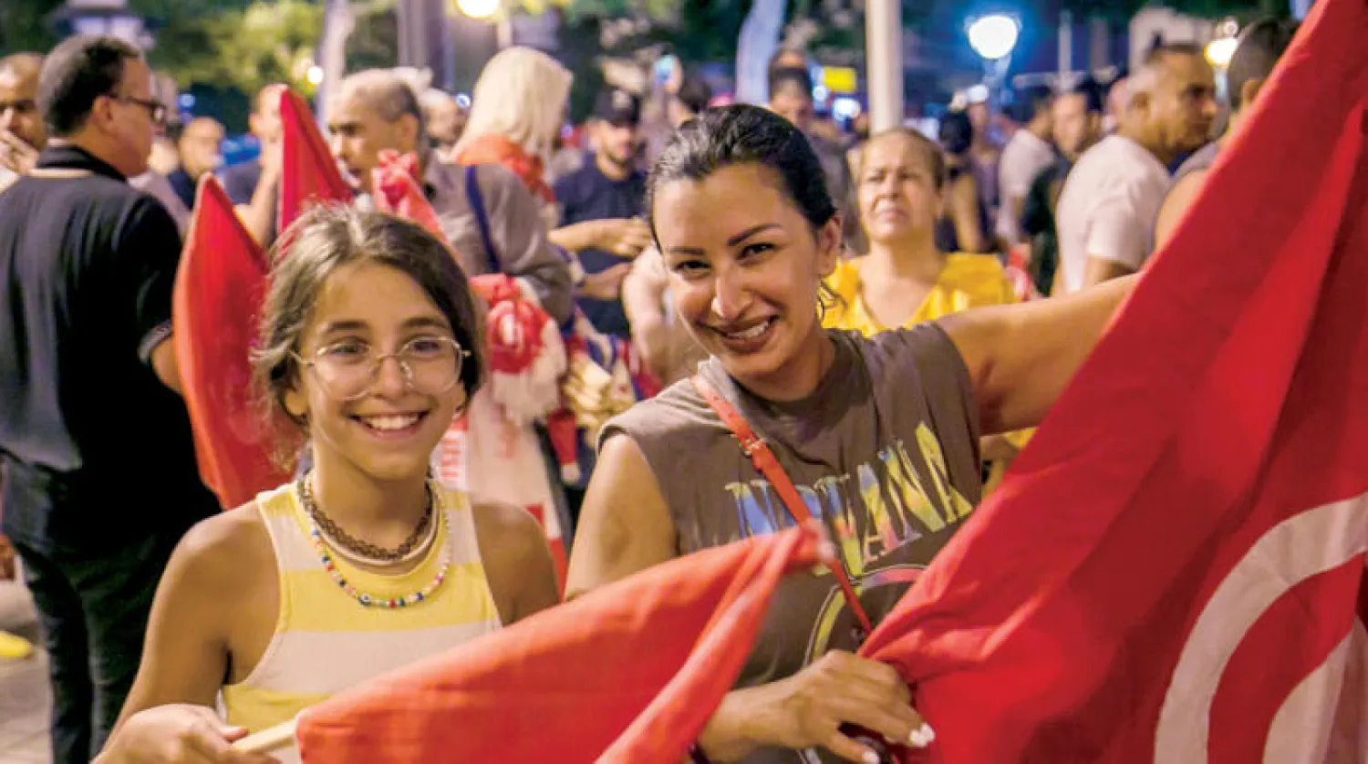 تونسيون يحتفلون بالإعلان عن نتائج التصويت على الدستور بـ«نعم» (أ.ب)