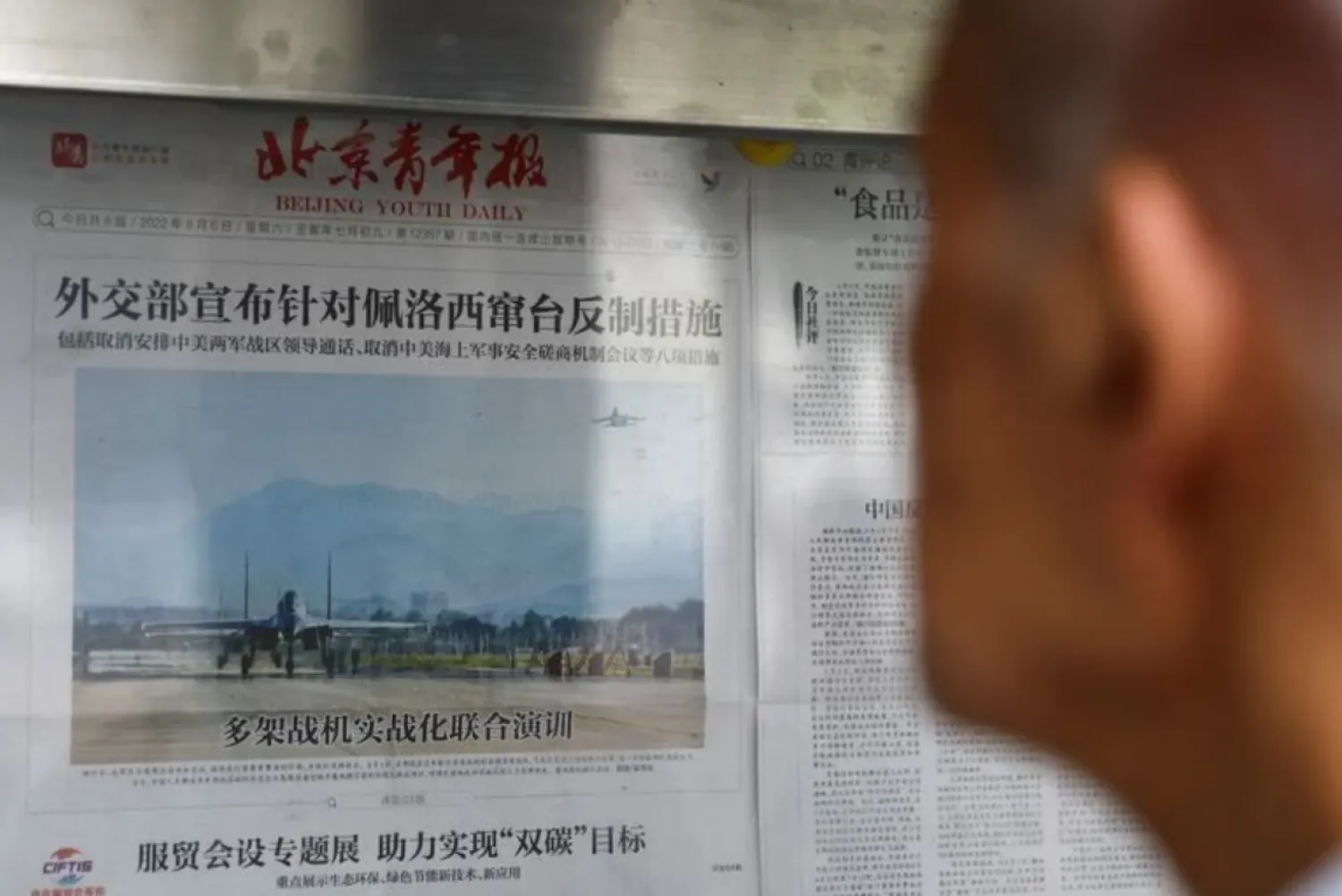 A man reads a newspaper report with an image of military exercises near Taiwan by the Chinese People's Liberation Army's (PLA) Eastern Theatre Command on the front-page, at a newspaper stand in Beijing, China, August 8, 2022. REUTERS/Tingshu Wang 