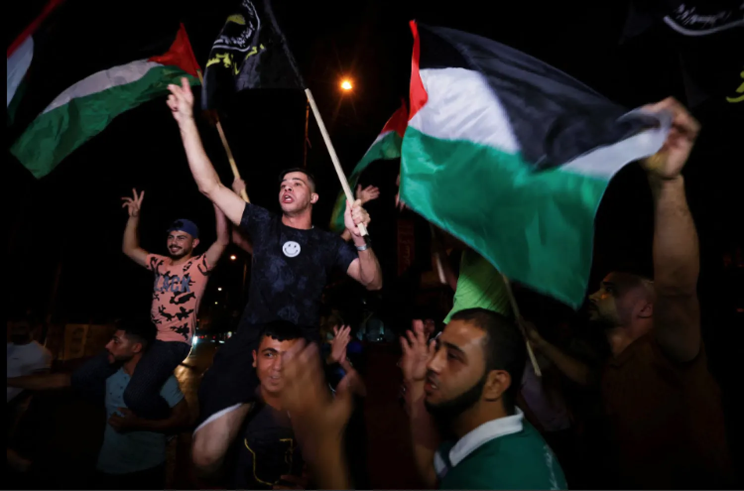 Palestinians celebrate on a street after a ceasefire was announced in Gaza City on August 8, 2022 (Reuters)

