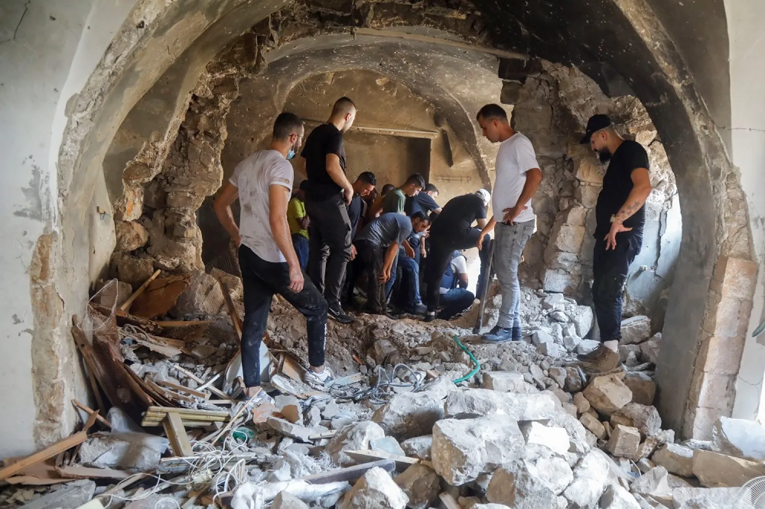 Palestinians inspect a building damaged during clashes between Palestinian militants and Israeli forces in a raid, in Nablus in the Israeli-occupied West Bank August 9, 2022. (Reuters)