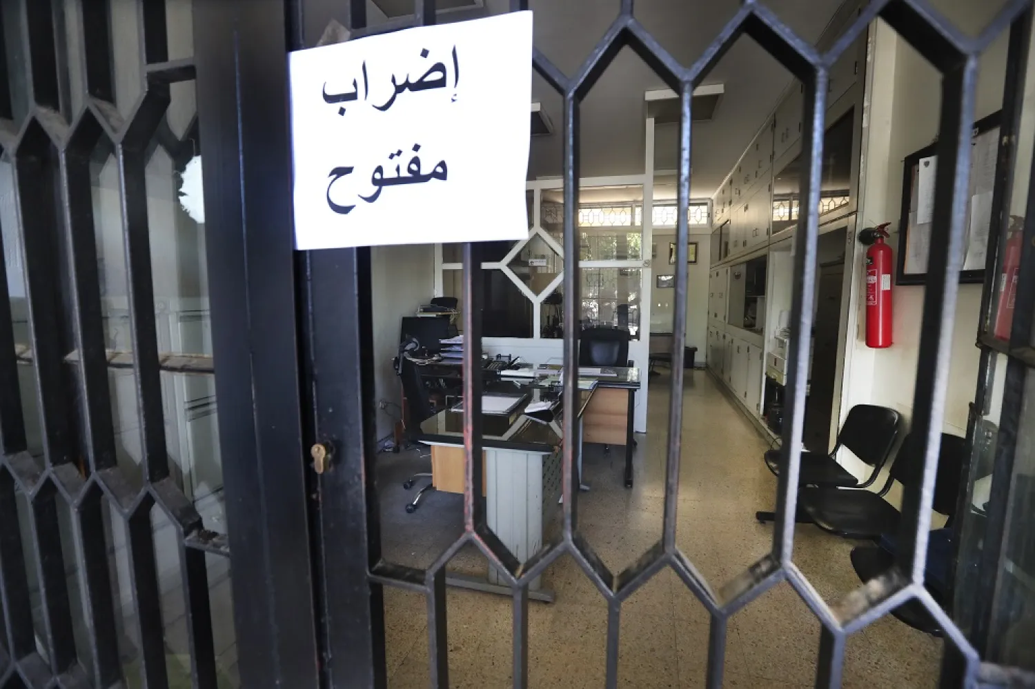 An Arabic placard reads: "Open strike", is posted on a door of an empty municipality office, in Bramiyeh, south Lebanon, July 27, 2022. (AP)