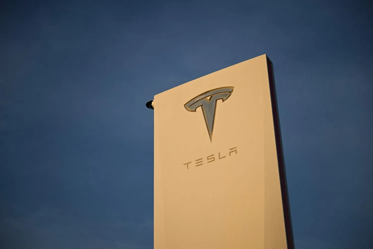 The Tesla, Inc. logo is displayed on a sign outside the Tesla Design Center in Hawthorne, California, on August 9, 2022. (AFP)