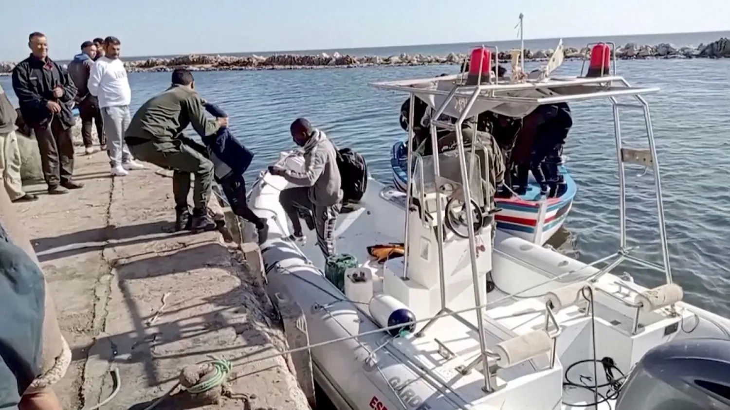 A Tunisian national coast guard helps a migrant child to get off a rescue boat. Reuters file photo