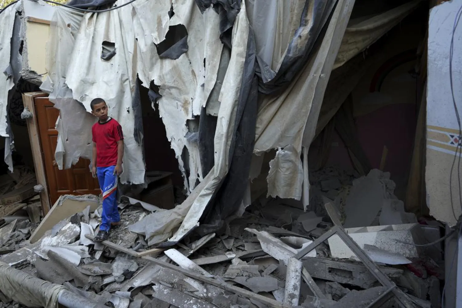 FILE - Mohammad Arada looks at the rubble of his family house after it was destroyed by an Israeli airstrike, in Rafah refugee camp, southern Gaza Strip, Monday, Aug. 8, 2022. (AP Photo/Adel Hana, File)
