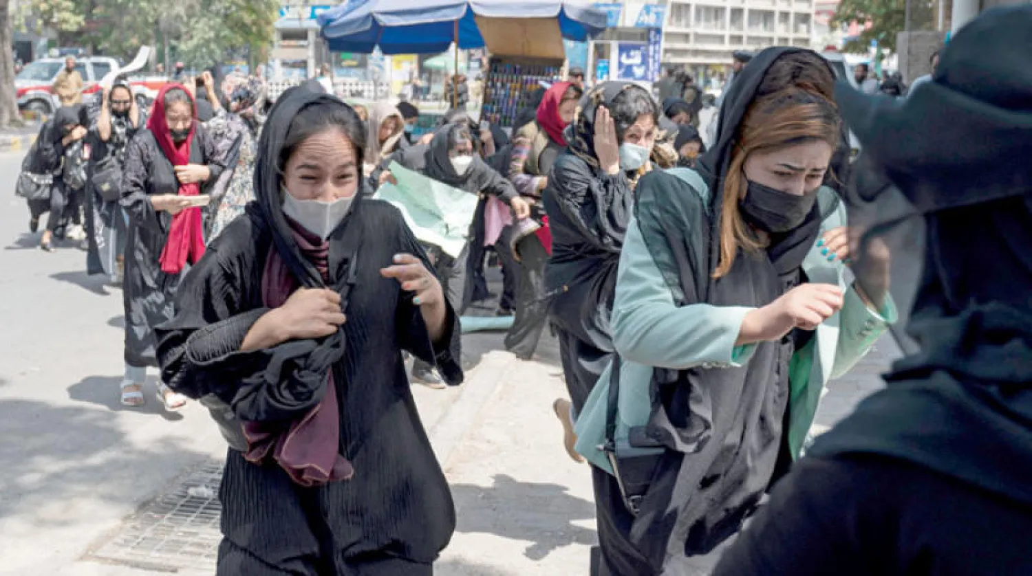 متظاهرات يهربن بعد إطلاق مسلحي «طالبان» الرصاص في الهواء أمس (أ.ف.ب)