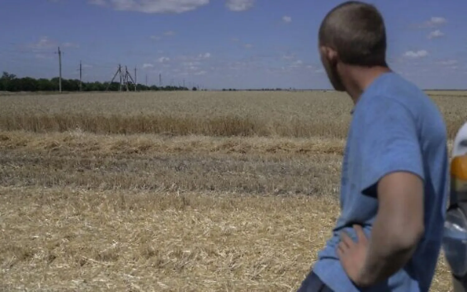 A farmer stands next to wheat field near Mykolaiv, Ukraine, July 21, 2022. (Bulent Kilic/AFP)

