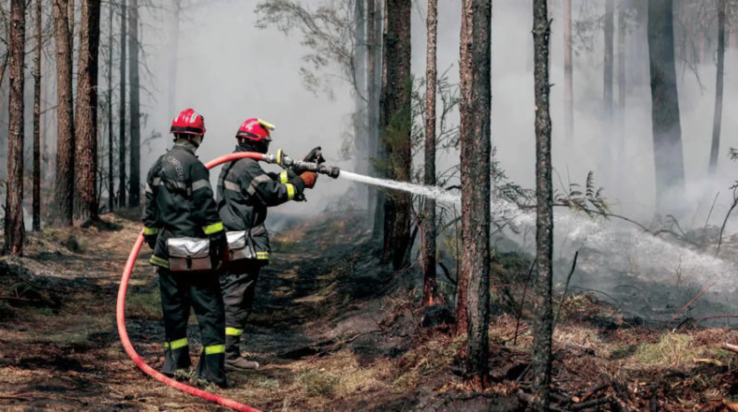 رجال إطفاء يخمدون بالماء البقع الساخنة العالقة التي خلفتها حرائق الغابات في جنوب غربي فرنسا (أ.ف.ب)