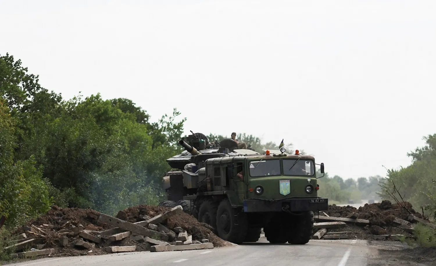 A Ukrainian serviceman gestures on a tank, as it is towed away by a military truck near Bakhmut, as Russia's invasion of Ukraine continues, in Donetsk region, Ukraine August 15, 2022. (Reuters)