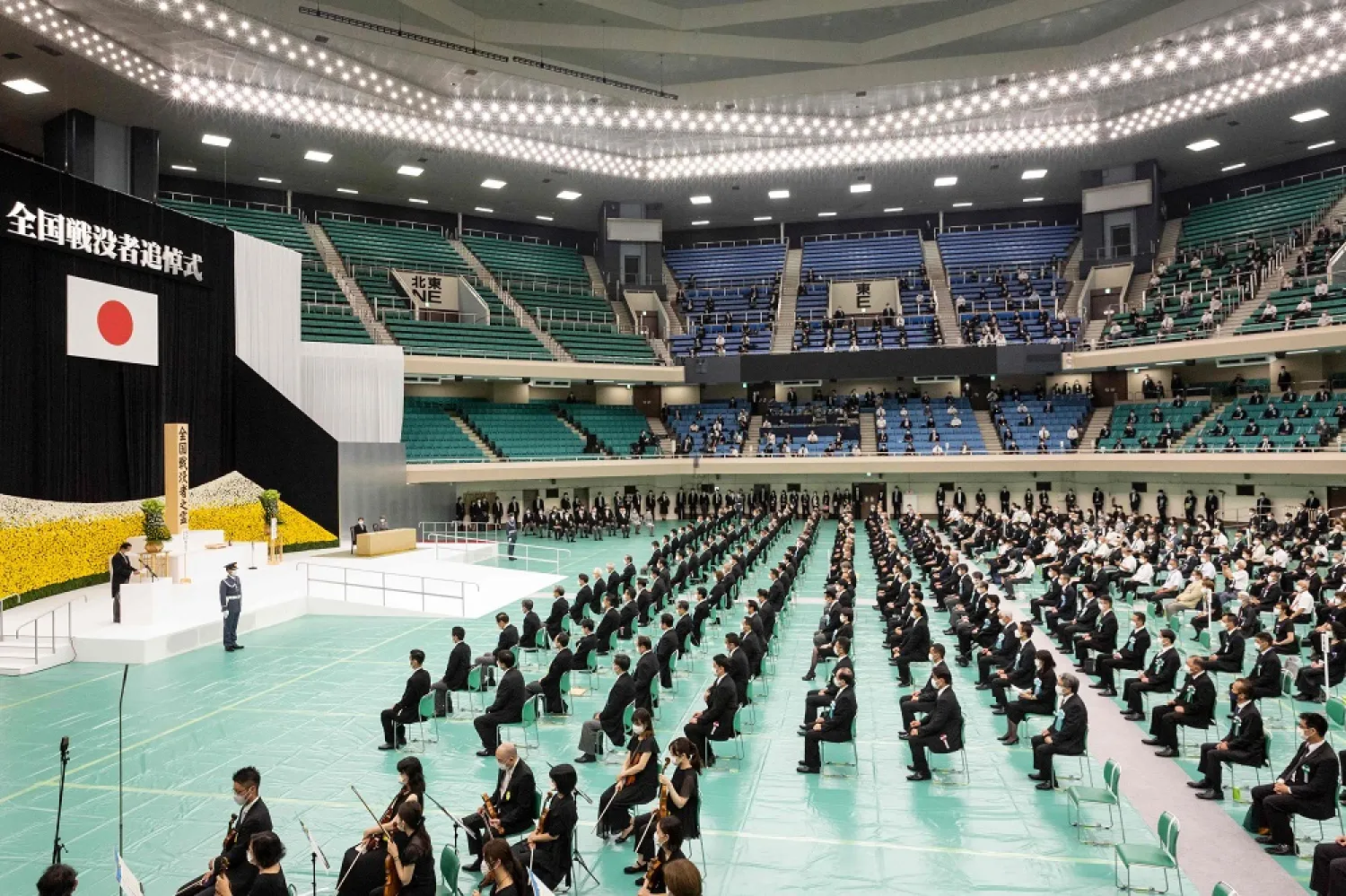 Japan's Prime Minister Fumio Kishida (L) speaks during a memorial service marking the 77th anniversary of Japan's surrender in World War II at the Nippon Budokan hall in Tokyo on August 15, 2022. (AFP)
