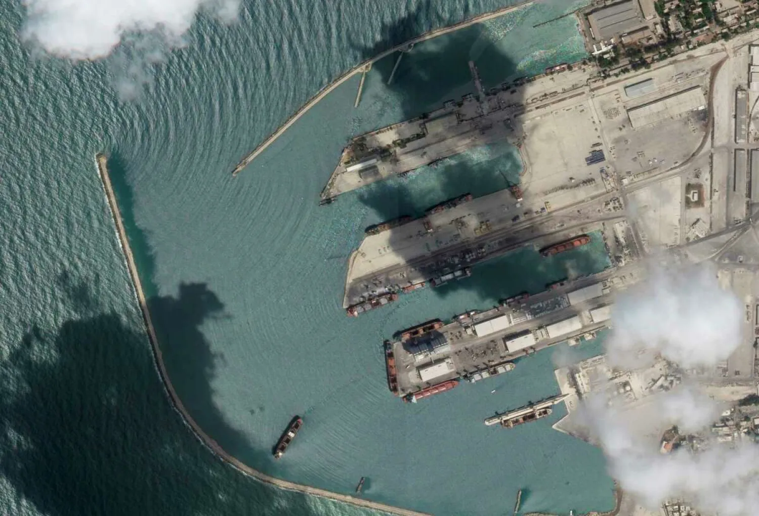 This satellite image from Planet Labs PBC shows the Sierra Leone-flagged cargo ship Razoni, center bottom with four white cranes on its red deck, at port in Tartus, Syria, Monday, Aug. 15, 2022. The Associated Press - (Planet Labs PBC via AP)

