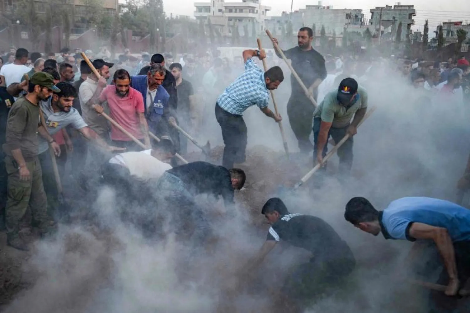 رجال يحفرون قبراً خلال جنازة مقاتل من قوات سوريا الديمقراطية في القامشلي قتل في غارة جوية نفّذتها طائرة تركية (أ.ف.ب)