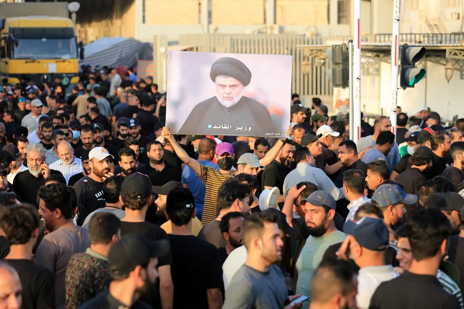 Supporters of Iraqi Shiite cleric M0qtada al-Sadr, head of the Sadrist movement, carry his picture in front of the gate of the Iraqi parliament building, Baghdad, Iraq, 12 August 2022. (EPA)