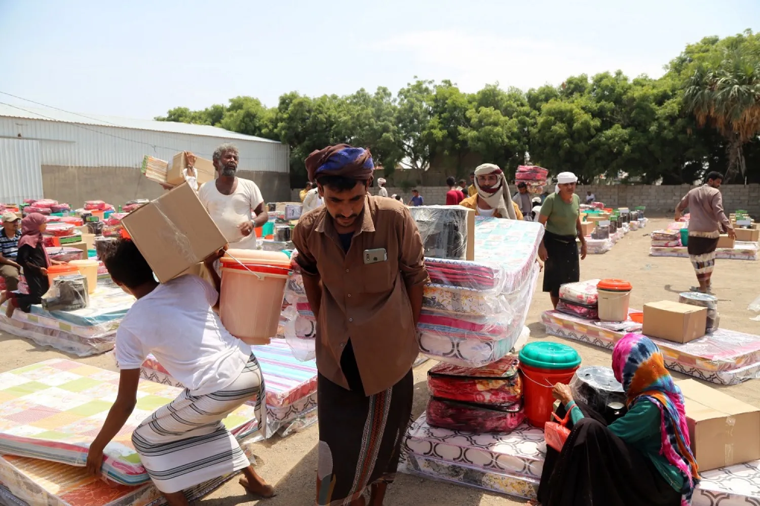Displaced Yemenis receive aids of tents, mattresses and bedding, after their camp was exposed to heavy rain that damaged their tents, in the Khokha district of the country's war-ravaged western province of Hodeidah, on August 12, 2022. (AFP)