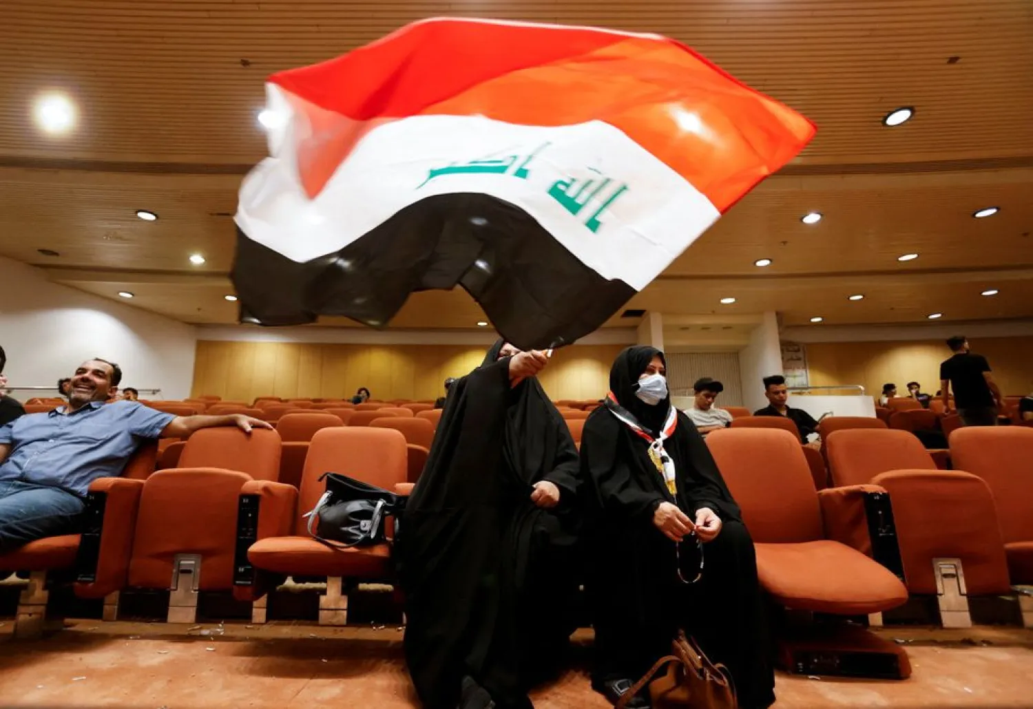 A woman holds an Iraqi flag as supporters of Iraqi populist leader Moqtada al-Sadr gather during a sit-in at the parliament building, amid political crisis in Baghdad, Iraq August 3, 2022. REUTERS/Ahmed Saad