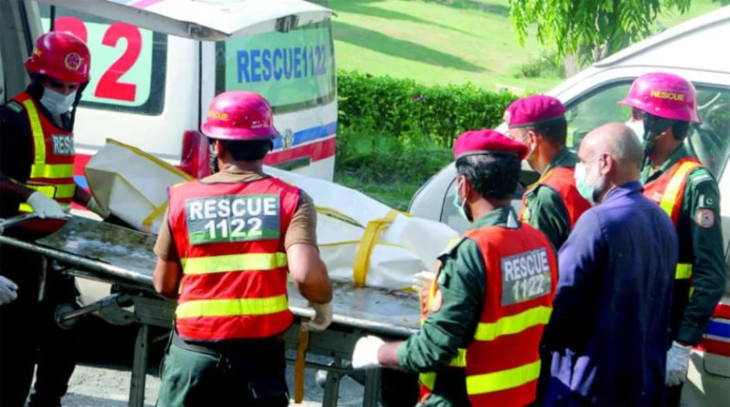 Kurtarma ekipleri, dün Multan'da Nishtar Hastanesi'nde, alev alan bir petrol tankeri ile yolcu otobüsünün çarpışması sonucu hayatını kaybeden bir kişinin cesedini taşıyor (Reuters) 