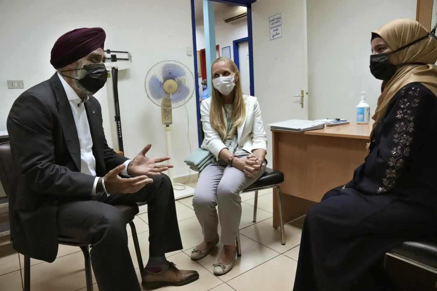Canadian Minister of International Development Harjit Sajjan, left, speaks with a Syrian refugee woman during his visit with the Canadian Ambassador to Lebanon Chantal Chastenay, center, to Makassed primary health care center, in Beirut, Lebanon, Wednesday, Aug. 17, 2022. (AP Photo/Hussein Malla)
