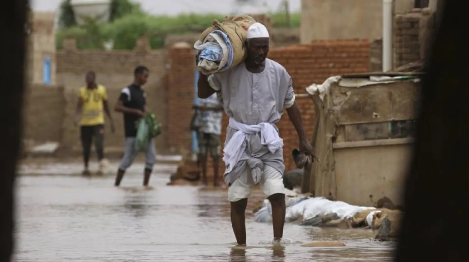 A man carries belongings as he wades through of a flooded road in the town of Shaqilab, about (25 km) southwest of the capital, Khartoum, Sudan, Monday, Aug. 31, 2020. (AP Photo/Marwan Ali)
