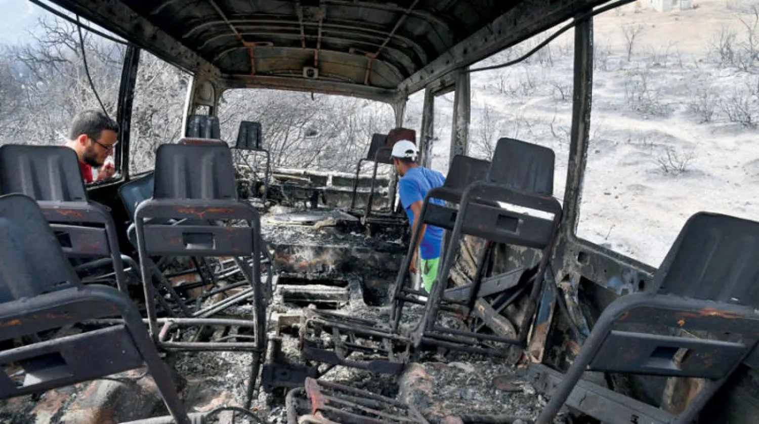 بقايا حافلة بعد احتراقها في ولاية الطارف أمس (أ.ف.ب)