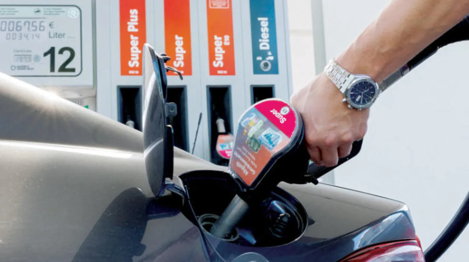 سائق سيارة يعيد تزويد سيارته بالوقود في محطة وقود في ميونيخ (رويترز)