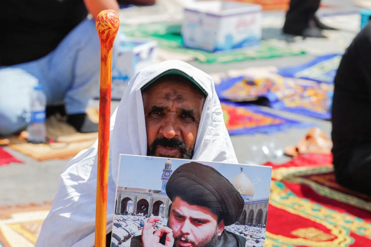 A supporter of Iraqi populist leader Moqtada al-Sadr attends the mass Friday prayer outside the parliament near the Green Zone, in Baghdad, Iraq August 19, 2022. (Reuters)