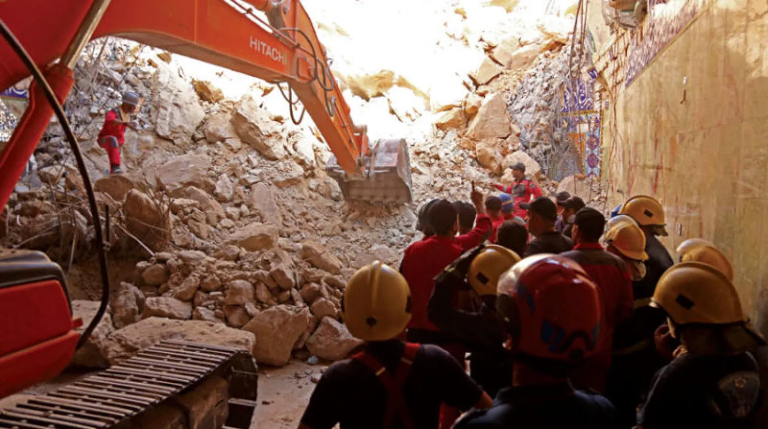 عمال الإنقاذ يحاولون الوصول إلى العالقين في مزار ديني قرب كربلاء أمس (أ.ف.ب)