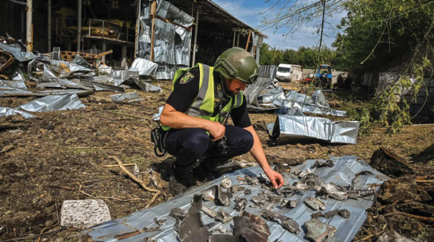 شرطي يتفقد بقايا صاروخ استهدف قرية بالقرب من خاركيف أمس (أ.ف.ب)