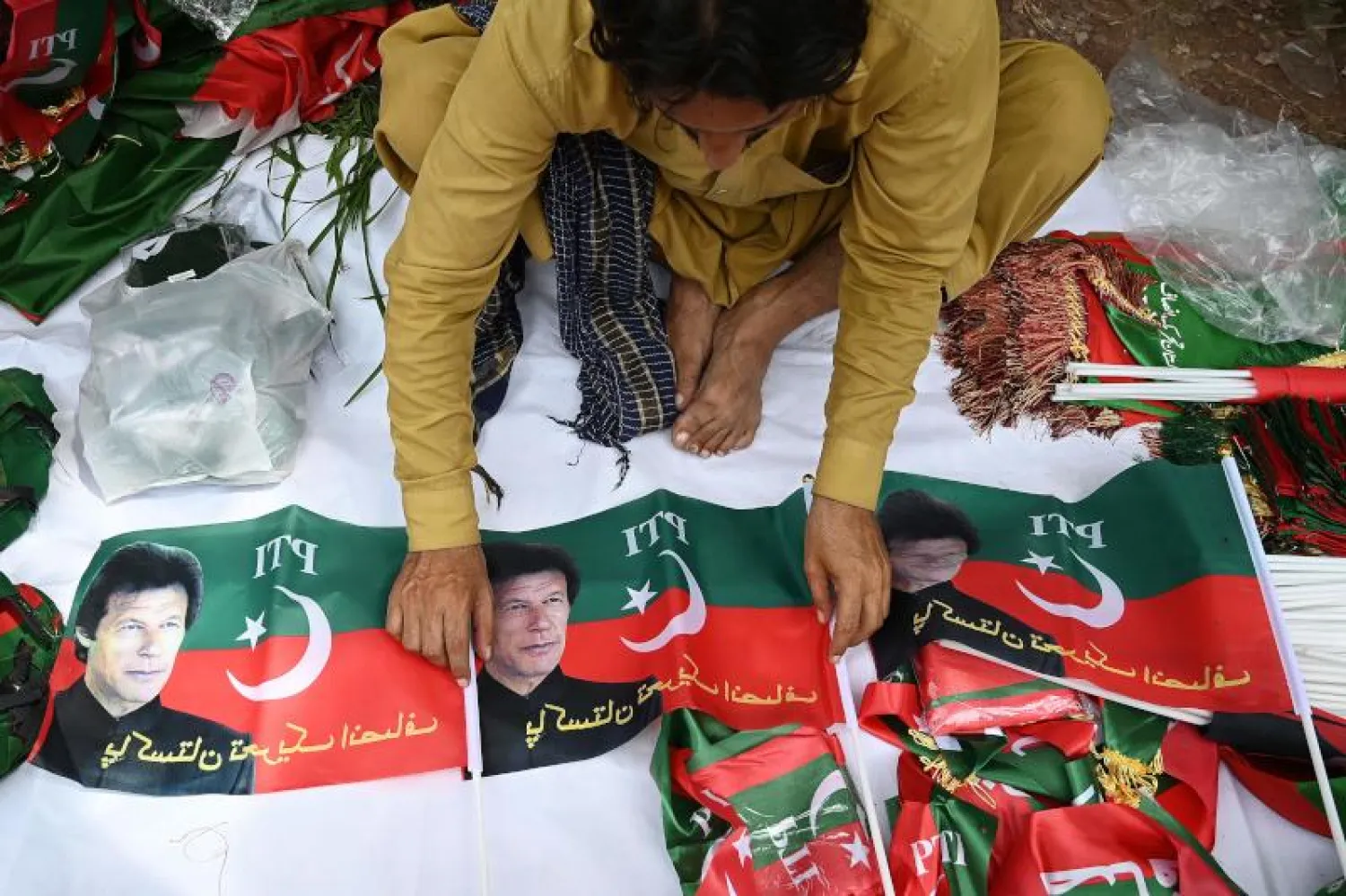 أنصار عمران خان يجهزون لافتات تضامنية معه خارج منزله لدى حي بني غالا (أ.ف.ب)