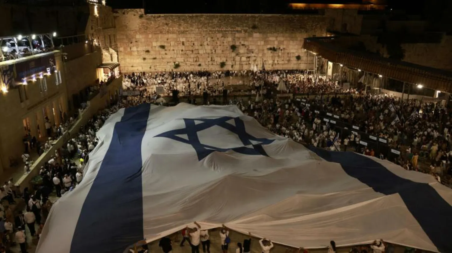 Israelis wave the national flag on the eve of the 'flag march' to mark Jerusalem Day, which commemorates the unification of the city Menahem KAHANA AFP
