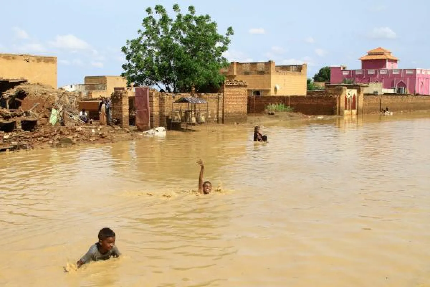 TOPSHOT - Sudanese children swim in flood water in the town of Iboud, 250kms south of the capital Khartoum, on August 22, 2022. (Photo by Ebrahim Hamid / AFP)
