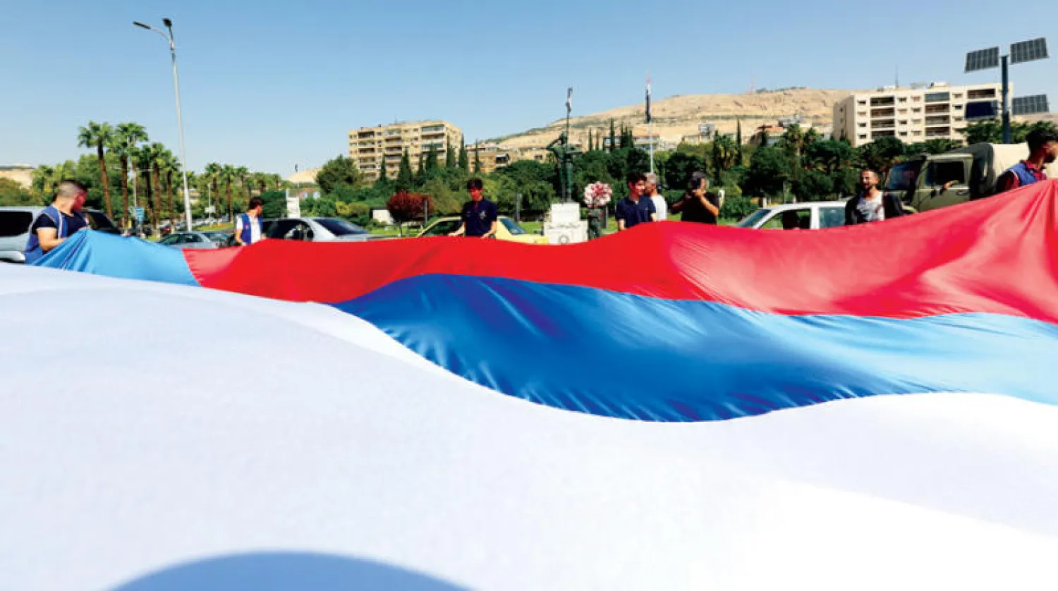 تلويح بعَلم روسي كبير في ساحة الأمويين في دمشق الاثنين (إ.ب.أ)