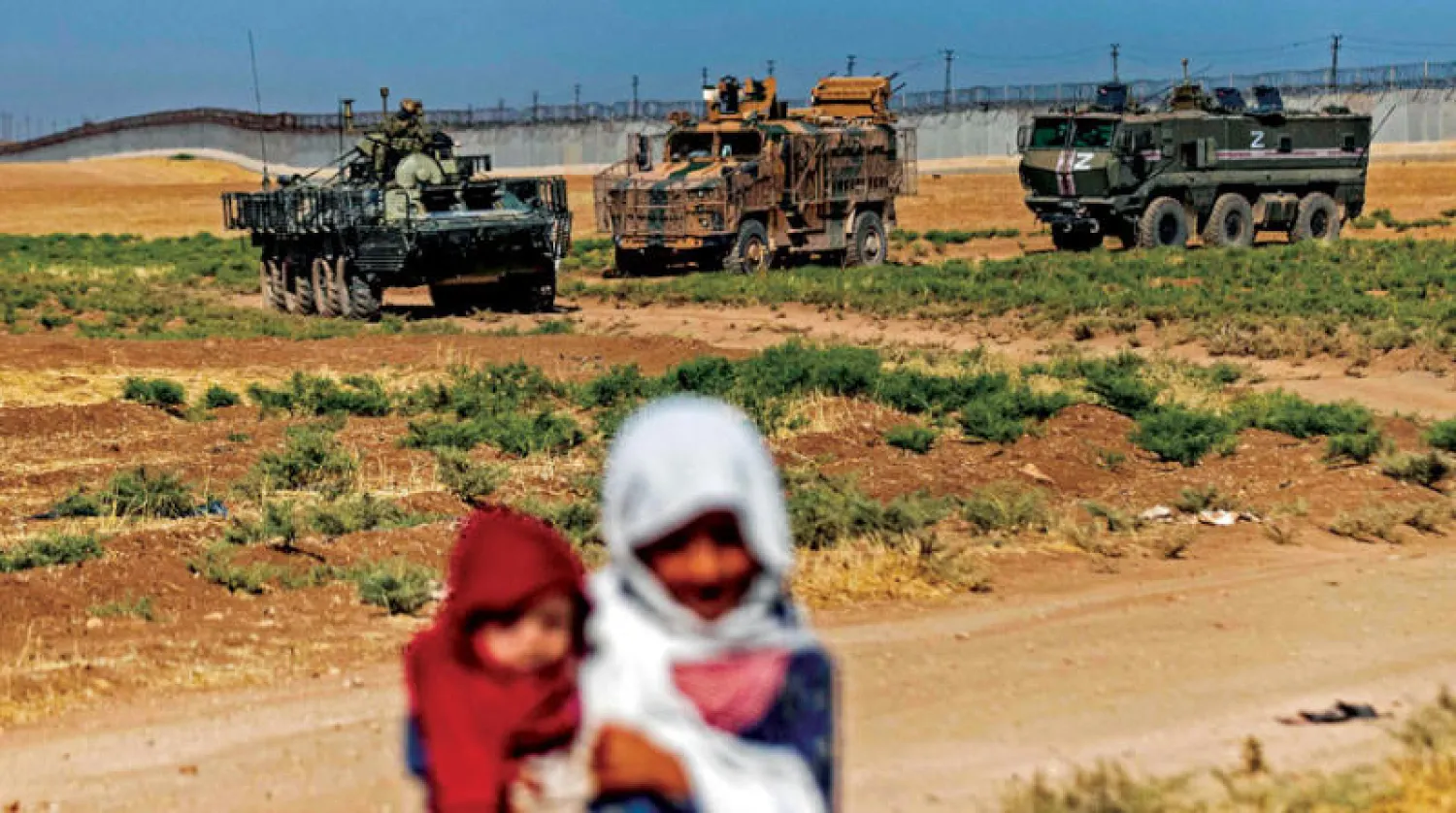 أطفال قرب دورية روسية ـ تركية مشتركة في ريف الدرباسية شمال شرقي سوريا في 28 يوليو (أ.ف.ب)