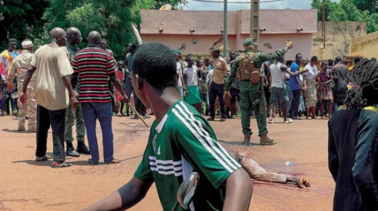 رجل يشتبه في مشاركته بهجوم «إرهابي» تم إحباطه يرقد بلا حراك على الأرض بعد تعرضه للضرب من قبل حشد أمام قاعدة عسكرية في كاتي (مالي) يوليو الماضي (أ.ف.ب)