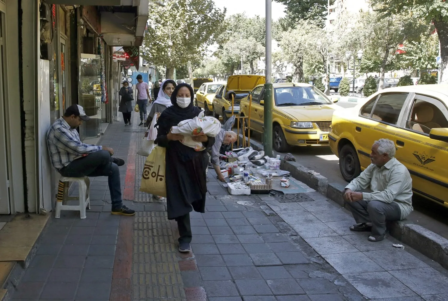 Iranians walk in a street in the capital city of Tehran, on August 25, 2022. (AFP)