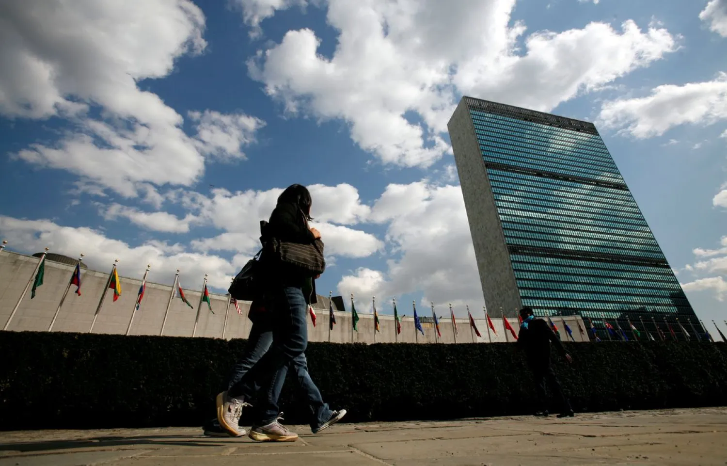 Tourists walk past the United Nations Headquarters in New York, March 24, 2008. At left is the UN General Assembly building and at right is the UN Secretariat building. REUTERS/Mike Segar
