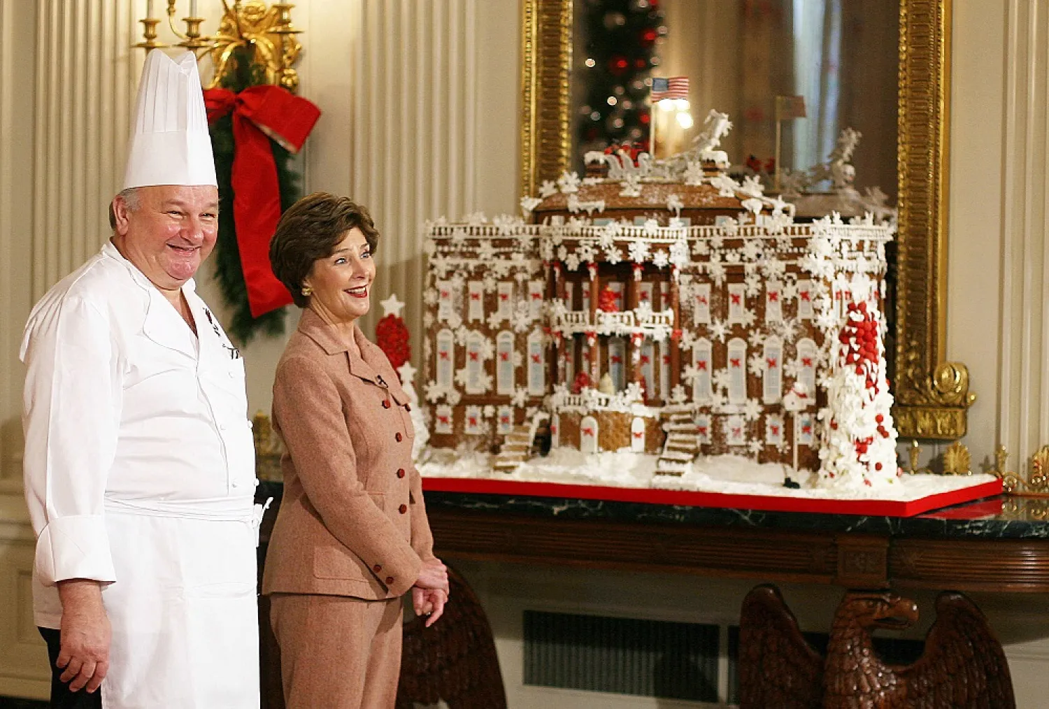 In this file photo taken on November 30, 2006, US First Lady Laura Bush (R) stands with Guest Pastry Chef Roland Mesnier (L) while talking about the ginger bread White House he created for the State Dining Room, during a media preview of the 2006 holiday decorations at the White House in Washington, DC. (AFP)