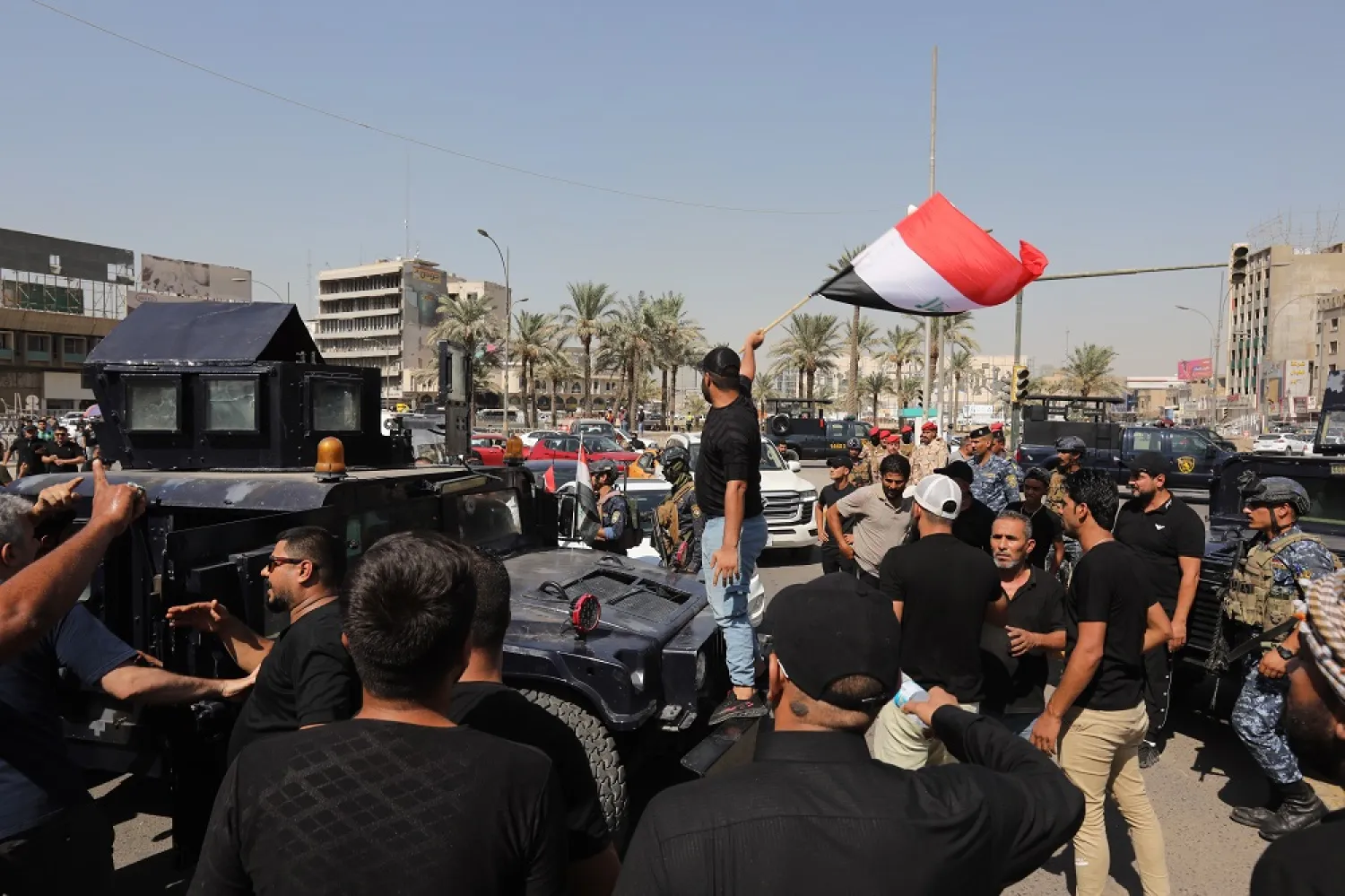 Supporters of Iraqi Shiite cleric Moqtada al-Sadr stand in front of security forces near the office of prime minister, Baghdad, Iraq, 29 August 2022. (EPA)