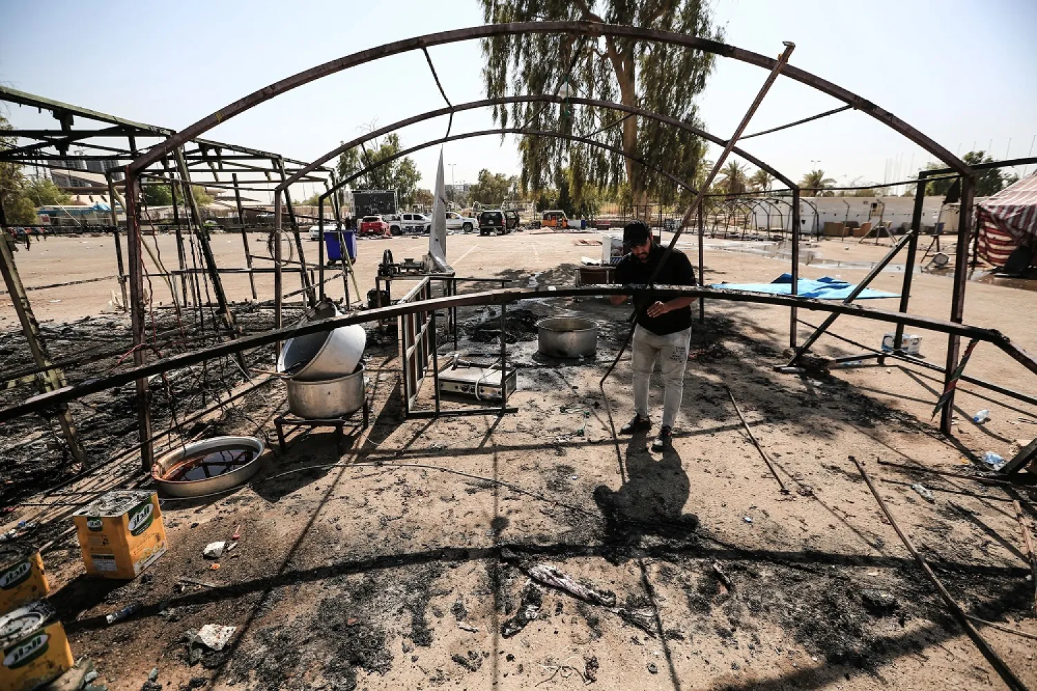 30 August 2022, Iraq, Baghdad: A supporter of Iraqi influential Shiite cleric Moqtada Al-Sadr, dismantles an encampment near the parliament building inside Baghdad's Green Zone, as Shiite protesters withdraw from their protest site. (dpa)